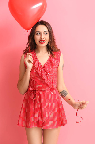 Beautiful young woman with balloon on color background. Valentine's Day celebration - 写真・画像