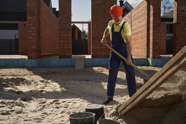Man builder working with shovel on construction site - Foto, Bild