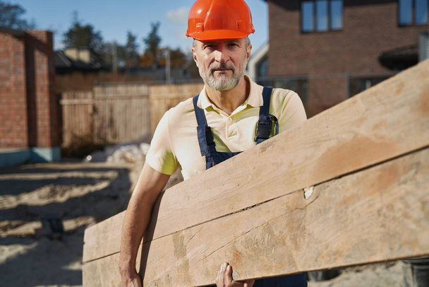 Construction worker with board staring into camera - Fotografie, Obrázek