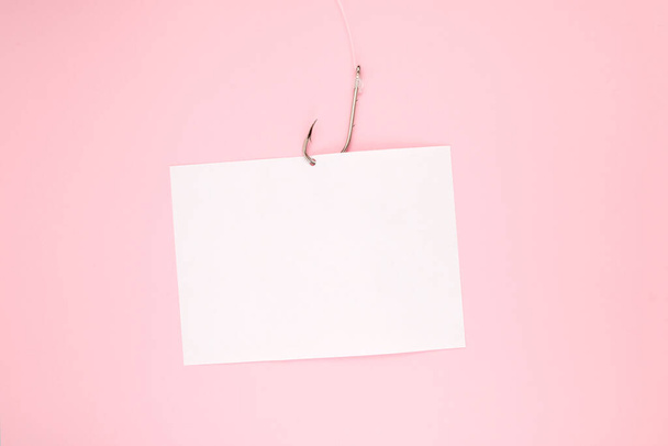 White paper sheet for text and fishing hook with fishing line on pink background. Design element, copy space. - Foto, Imagem