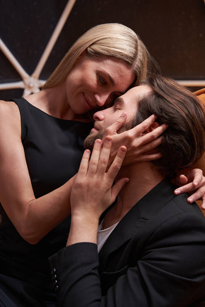 Caring woman touching man cheek while sitting on him - Fotografie, Obrázek