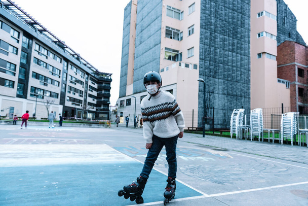 Caucasian boy practises roller skating in a city park - Fotó, kép