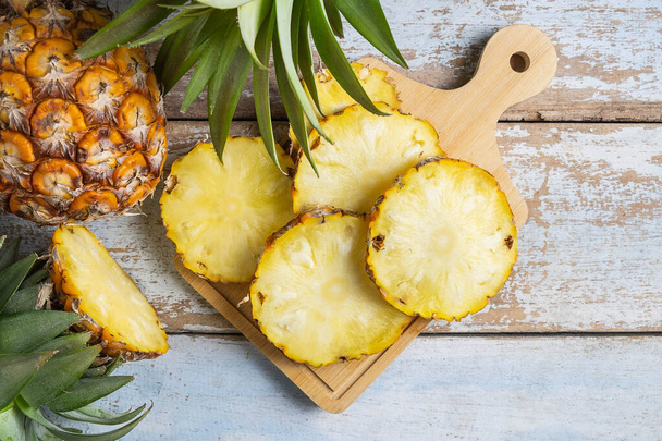 Fresh pineapple fruit sliced on  wooden cutting board - Zdjęcie, obraz