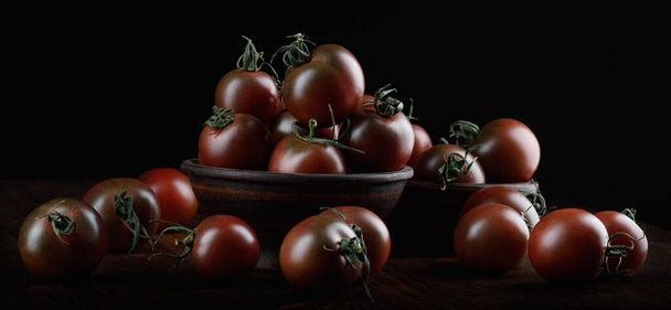 A lot of ripe juicy tomatoes on a black background. Cumato tomatoes. - Fotoğraf, Görsel