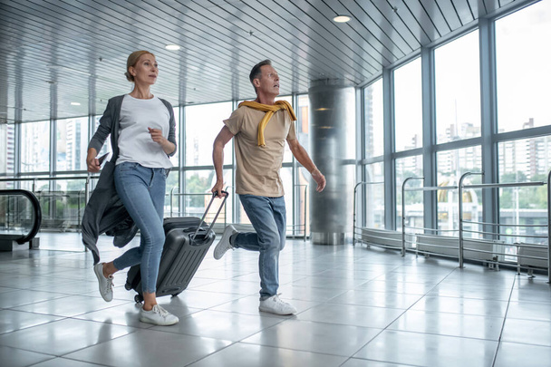 Two excited tourists hurrying to catch the flight - Foto, imagen
