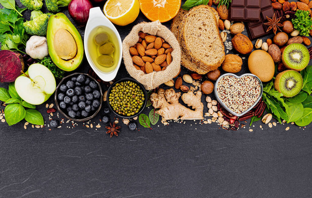 Συστατικά για την επιλογή υγιεινών τροφίμων. Η έννοια των υγιεινών τροφίμων που έχουν συσταθεί σε σκούρο πέτρινο φόντο. - Φωτογραφία, εικόνα