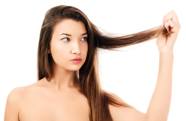 woman looking on her fragile hair, white background, copyspace - Photo, Image