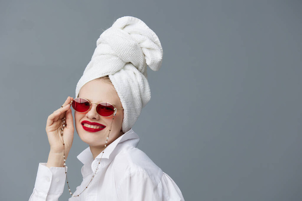 mujer de moda con una toalla en la cabeza en una camisa blanca modelo de estudio sin cambios - Foto, imagen