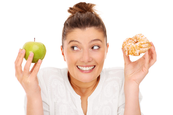 Mujer eligiendo entre manzana y donut
 - Foto, imagen