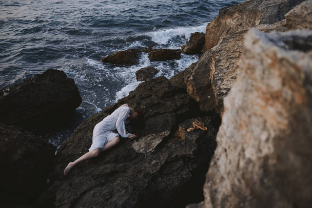 чувственная женщина в белом платье лежащая на камне в белом платье пейзаж - Фото, изображение