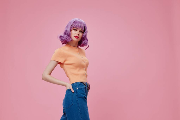 pretty glamorous woman purple hair in jeans pink background - Zdjęcie, obraz