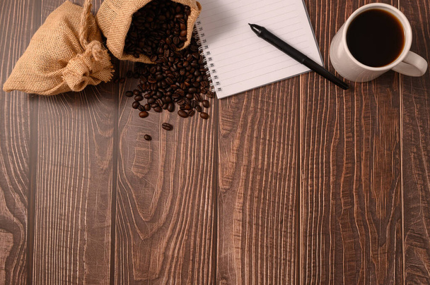Coffee and a notebook are at your desk. - Фото, изображение