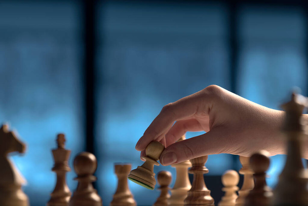Professional player moving a pawn on the chessboard, strategy games concept - Foto, Imagen