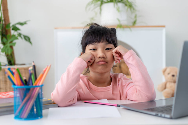 Unhappy little Caucasian girl child sit at table at home feel lazy unmotivated doing homework assignment. Upset distressed small 7s kid prepare school task, learn study with books. Education concept. - Photo, Image
