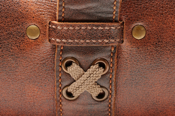 Cloth buckle and lock on brown leather macro close up view - Fotó, kép