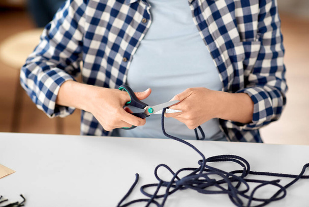 woman cutting macrame cords with scissors - Photo, Image