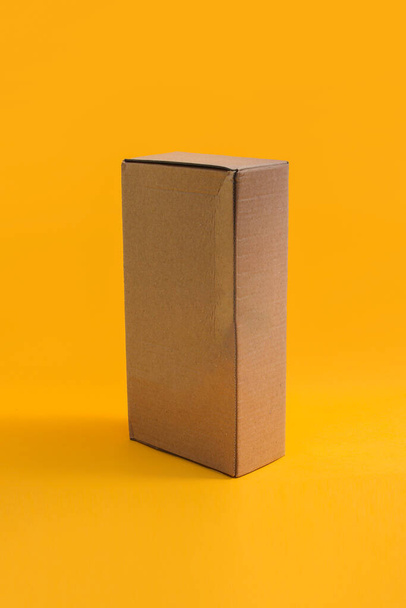 Hnědá lepenková krabice izolované na oranžovém pozadí - Fotografie, Obrázek