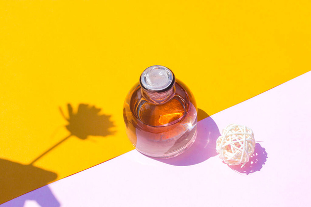 Frasco de perfume de 50 ml con flor y billetera sobre fondo naranja-rosa. Perfume botella stock foto - Foto, Imagen