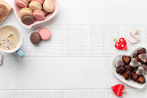 Homemade macaroons, heart chocolate and coffee cup. Top view flat lay with copy space. Valentines day - Photo, Image