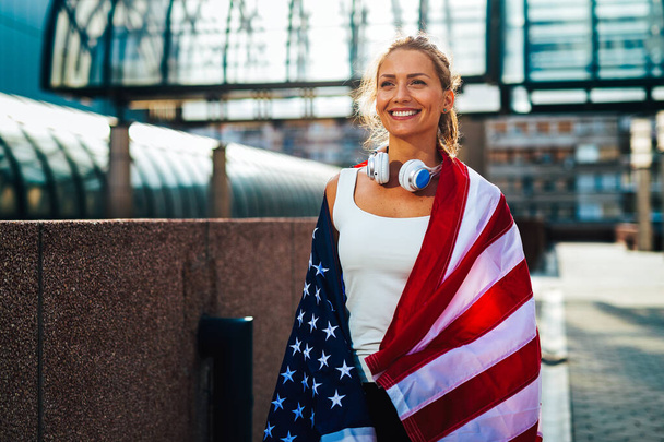 Portrait of beautiful young fit woman with USA flag. Sport people happiness success healthy lifestyle concept - Фото, изображение