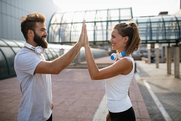 Happy young runner couple exercising outside as part of healthy lifestyle. People sport running concept - Φωτογραφία, εικόνα