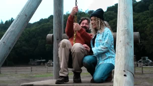 Взрослый мужчина на веревке в парке и его жена - счастливые пожилые люди, наслаждающиеся на открытом воздухе свободы концептуального образа жизни - Кадры, видео