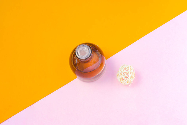 Frasco de perfume de 50 ml com flor e carteira sobre fundo laranja-rosa. Frasco de perfume foto stock - Foto, Imagem