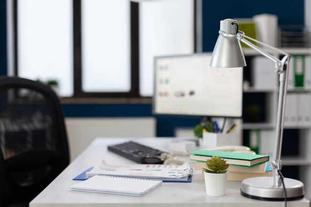 Primer plano de la lámpara en el escritorio blanco en la oficina moderna vacía del negocio. - Foto, Imagen
