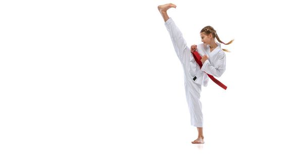 Flyer. Portrait of young girl, teen, taekwondo athlete practicing alone isolated over white background. Concept of sport, education, skills - Foto, Imagen