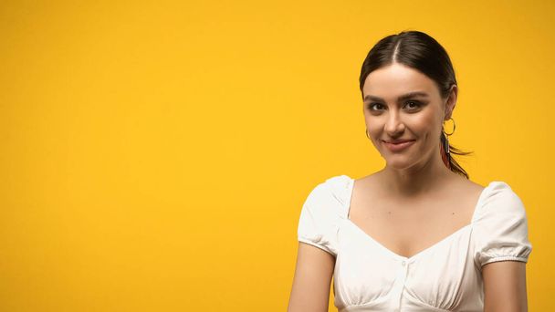Smiling woman in blouse looking at camera isolated on yellow  - Фото, зображення