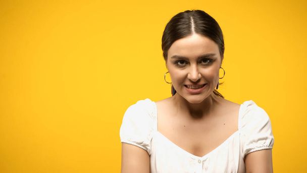 Aggressive woman in blouse looking at camera isolated on yellow  - Foto, afbeelding