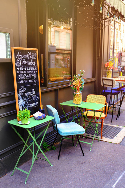 small french restaurant - table and chairs decorated with flowers on the street - Paris, France - Фото, изображение