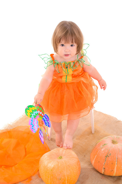 Little girl in orange costume with pumpkins - Fotografie, Obrázek
