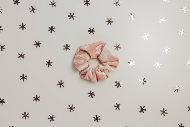 Un scrunchie en velours rose tendance et des flocons de neige argentés - Photo, image