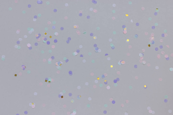 Multicolored confetti on gray background. Carnival and festive holiday concept - Fotó, kép