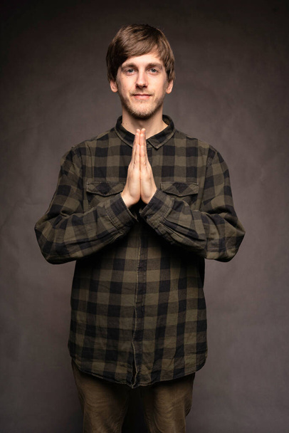 Young handsome tall slim white man with brown hair looking peaceful with flannel shirt on grey background - Fotoğraf, Görsel