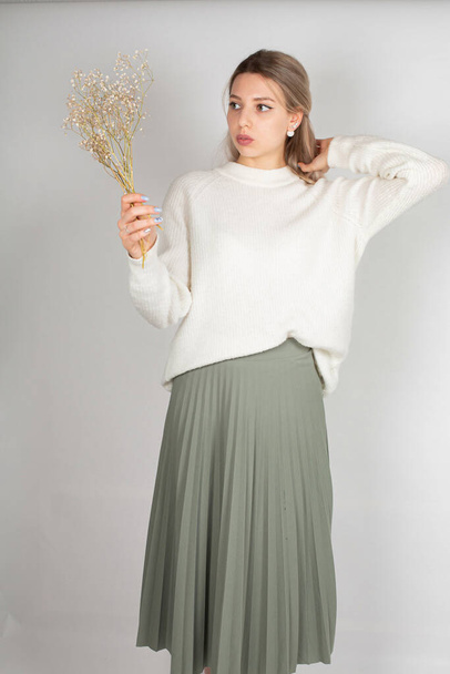 Romantic woman with long hair and white skin isolated on grey in white sweater and olive skirt - Foto, afbeelding