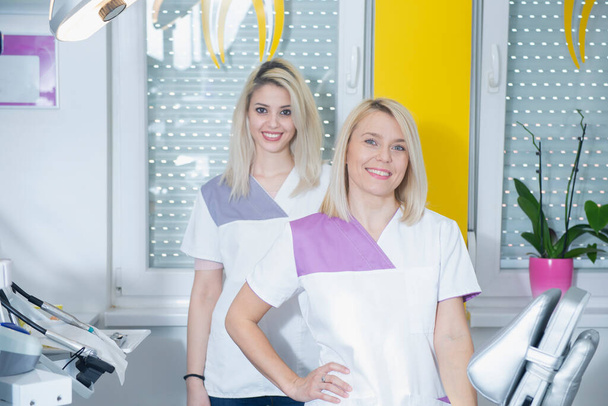 Two female dentists standing in their clinic - Фото, изображение