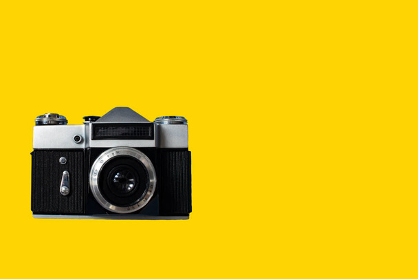Close-Up of Camera Against Yellow Background. Vintage camera, old film camera isolated on yellow with clipping path for object, retro technology. - Photo, image