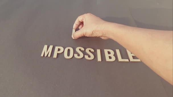Impossible Means Im Possible If You Know How To Begin - Man hand separating I M letter from impossible an adding a smiley to say possible. Success and achievement determination concept. - Materiał filmowy, wideo
