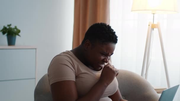 Enfermo sobredimensionado negro mujer estornudo usando portátil trabajando en casa - Metraje, vídeo
