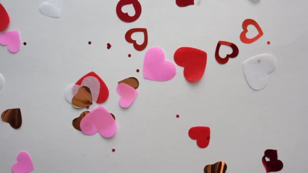 Sydämen muotoinen konfetti lentää valkoisella taustalla - Materiaali, video