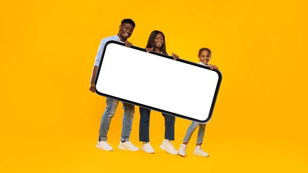 Black family holding heavy white empty smartphone screen - Photo, Image