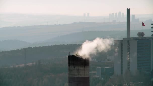 8K 4320p 7680x4320.Industrial chimney polluting air.Industrial roof with chimneys polluting the atmosphere at a cloudy day.Damage to nature through factory and industry.There is a forest in the background of the chimney.Clean green forest - Séquence, vidéo