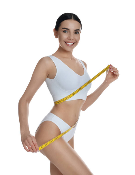 Young woman measuring waist with tape on white background - Fotografie, Obrázek