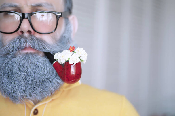 Guy smoking tobacco pipe. Hipster grey beard and mustache. Bad habits concept - 写真・画像