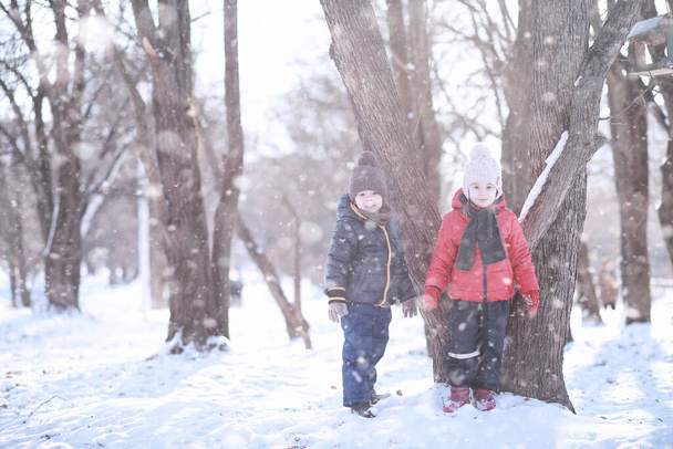 Gyerekek sétálnak a parkban az első hóban  - Fotó, kép