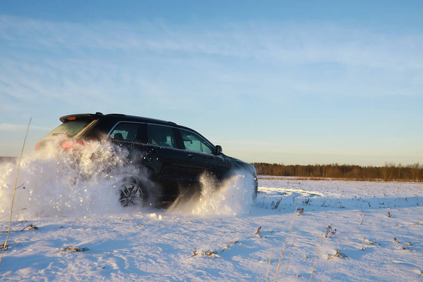 Araba, kışın tarlada. Off-road kış karları sürükleniyor. Olağanüstü spor, eğlence. - Fotoğraf, Görsel