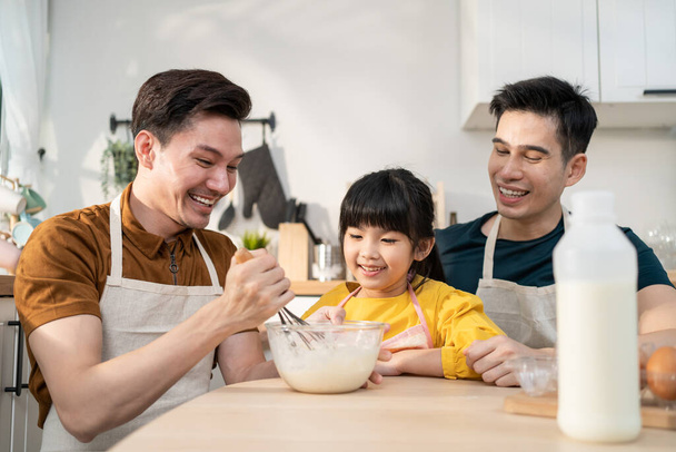 Aasian houkutteleva LGBTQ homo perhe opettaa tyttö lapsi tekee hiiva taikina. Komea miespari hoitaa ja viettää aikaa vähän ihana lapsi leipoa leipomo keittiössä, nauttia vanhemmuuden toimintaa kotona. - Valokuva, kuva