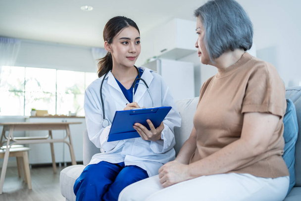 Asian caregiver psychology doctor examine and listen to woman patient. Young beautiful Woman nurse give advise and consult to help senior female solve problem at nursing home. Psychologic health care. - Foto, Imagem